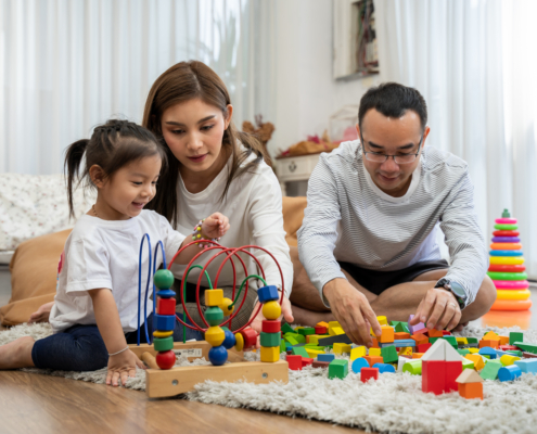 Parents participating in ABA therapy by playing with their child